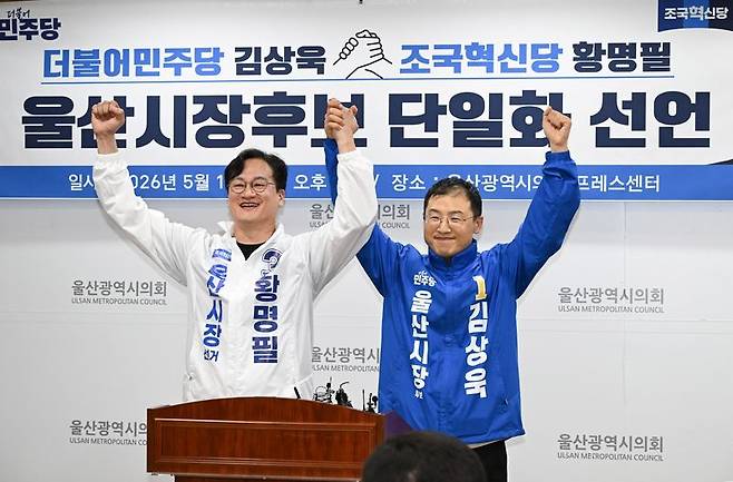 더불어민주당과 조국혁신당이 울산시장 후보 단일화에 전격 합의하면서 14일 황명필 조국혁신당 울산시장 후보와 김상욱 더불어민주당 울산시장 후보가 기자회견 후 손을 잡고 선거 승리를 다짐하고 있다. 울산시의회 제공