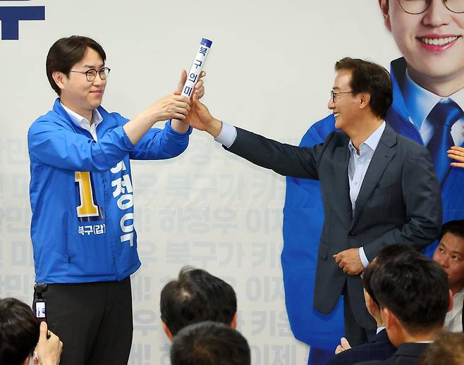 부산 북갑 국회의원 보궐선거에 출마하는 하정우(왼쪽) 더불어민주당 후보가 10일 부산 북구 선거사무소 개소식에서 전재수 부산시장 후보에게서 '북구의 미래'가 적힌 배턴을 넘겨받고 있다. 부산=연합뉴스