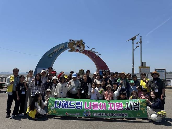 향남읍 지역사회 보장협의체 관계자들과 참여 가족들이 다해드림 나들이 지원 행사에서 기념촬영을 하고 있다. 사진제공 화성시