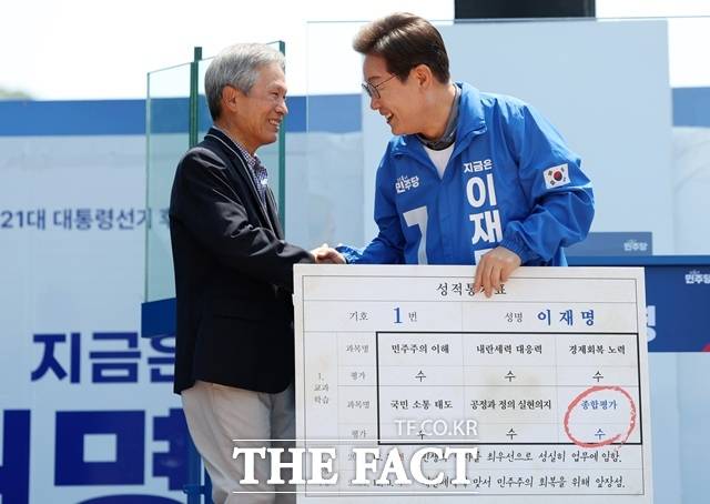 이재명 대통령은 15일 스승의날을 맞아 경북 안동의 한 식당에서 초등학교 은사인 박병기 선생님과 삼계초등학교 동문들을 만나 오찬을 함께했다. 2025년 6월 1일 당시 더불어민주당 대선후보였던 이 대통령이 경북 안동시 웅부공원에서 열린 유세에서 박 교사에게 대선후보 모의 성적통지표를 받고 있다. /뉴시스