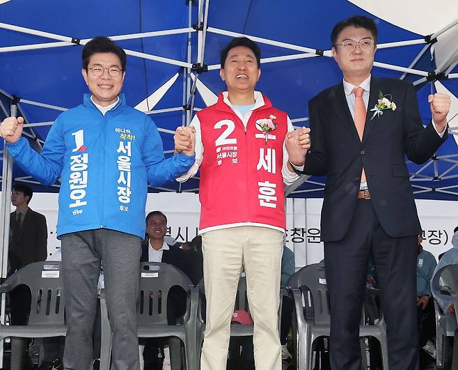정원오 더불어민주당 서울시장 후보(왼쪽부터)와 오세훈 국민의힘 서울시장 후보, 김정철 개혁신당 서울시장 후보가 지난 3일 오전 서울 용산구 효창운동장에서 열린 제44회 서울특별시장기 축구대회 개회식에 참석해 손을 맞잡은 채 포즈를 취하고 있다. 뉴스1