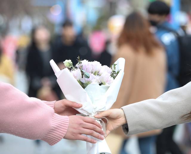 서울 마포구 홍대 앞 거리에서 연인이 꽃을 주고받고 있다. 뉴시스