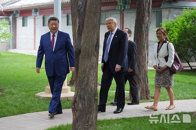 [베이징=AP/뉴시스] 도널드 트럼프(오른쪽) 미국 대통령과 시진핑 중국 국가주석이 15일(현지 시간) 중국 베이징 중난하이에서 만나 함께 걷고 있다. 2026.05.15.