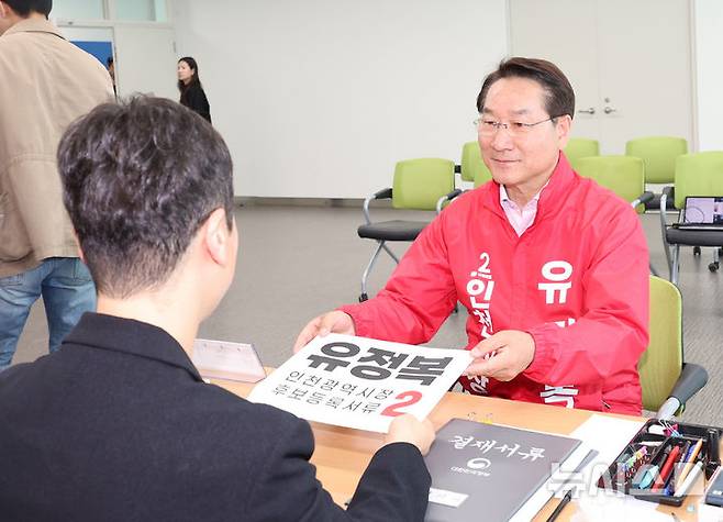 [인천=뉴시스] 전진환 기자 = 제9회 전국동시지방선거 후보 등록 첫날인 14일 인천 미추홀구 인천시선거관리위원회에서 유정복 국민의힘 인천시장 후보가 후보등록 신청서를 제출하고 있다. 2026.05.14. amin2@newsis.com