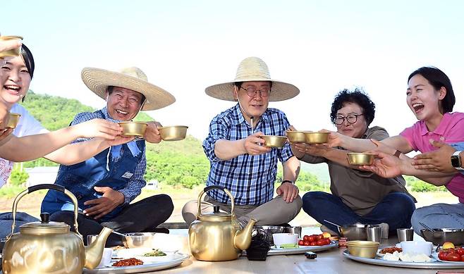 이재명 대통령이 15일 대구 군위군 소보면 도산1리 마을에서 열린 모내기행사에 새참을 시식하고 있다. [청와대사진기자단]