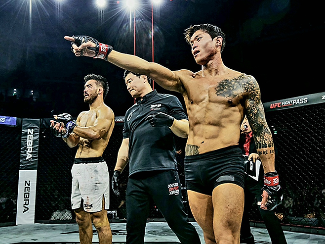 블랙컴뱃 웰터급 챔피언 최준서가 2026년 5월 서울올림픽핸드볼경기장 Z-Fight Night 04 승리 후 기뻐하고 있다. 왼쪽은 패배를 인정하는 UFC 4경기 조시 퀸란. ‘코리안 좀비’ 정찬성 대표의 ZFN은 UFC Fight Pass를 통해 중남미 제외 글로벌 생중계된다. 사진=MCP ECC
