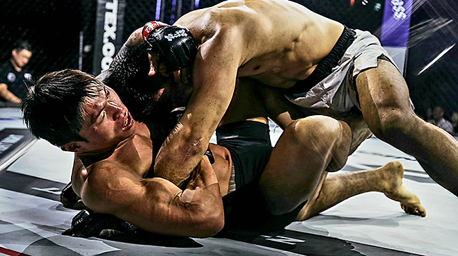 초대 블랙컴뱃 웰터급 챔피언 최준서가 2026년 5월 서울올림픽핸드볼경기장 Z-Fight Night 04 메인카드 제5경기에서 UFC 4경기 조시 마이클 퀸란한테 깔려있다. ‘코리안 좀비’ 정찬성 대표의 ZFN은 UFC Fight Pass를 통해 중남미 제외 글로벌 생중계된다. 사진=MCP ECC
