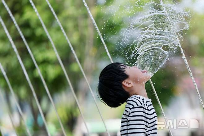 [서울=뉴시스] 김명년 기자 = 초여름 날씨를 보인 지난 14일 오후 서울 종로구 광화문광장 분수대 터널에서 한 아이가 물놀이를 하며 더위를 식히고 있다. 다음 주 월요일 대구 낮 최고 기온이 34도까지 오르는 등 무더위가 예상된다. 이후 수요일 전국적으로 비가 오면서 더위가 한풀 꺾이겠다. 2026.05.16. kmn@newsis.com