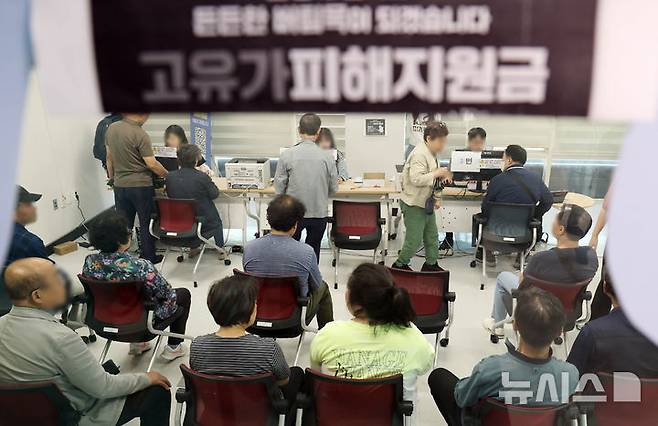 [부산=뉴시스] 하경민 기자 = 정부 고유가 피해지원금 2차 신청·지급 첫날인 18일 부산 부산진구 개금3동행정복지센터에서 주민들이 선불카드형 지원금을 받고 있다. 2026.05.18. yulnetphoto@newsis.com