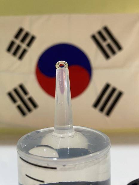 주사기 위에 맺힌 물방울에 태극기를 비춰보는 ‘물방울 태극기 촬영’