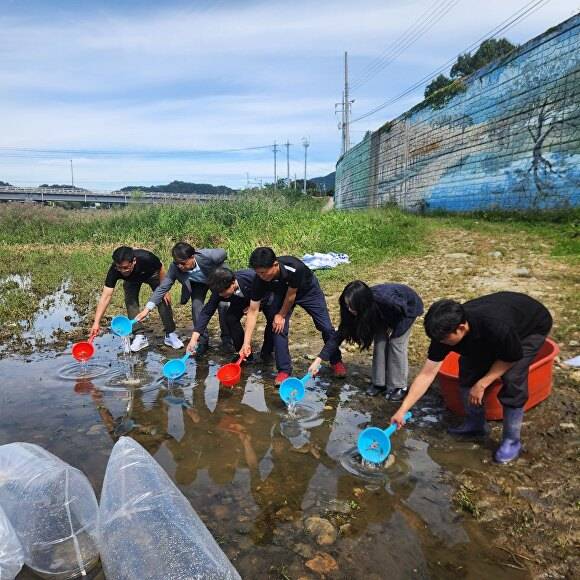 충북도 내수면산업연구소 관계자들이 괴산군 칠성면에서 쏘가리·동자개 등 치어를 방류하는 모습. [사진=충북도]