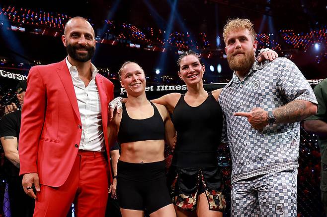 17일 넷플릭스 MMA 대회 메인이벤트가 끝난 뒤 MVP 관계자와 선수들이 나란히 기념 촬영하고 있다. 왼쪽부터 MVP 공동설립자 나키사 비다리안, 여성 파이터 론다 로우지와 지나 카라노, 공동설립자인 복싱 인플루언서 제이크 폴. [게티이미지]