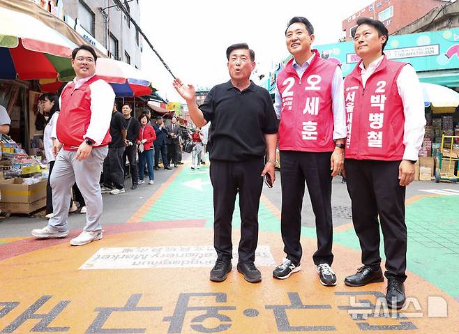 [서울=뉴시스] 최진석 기자 = 오세훈 국민의힘 서울시장 후보가 19일 서울 종로구 창신동 문구완구거리에서 오세훈과 함께 걸어요를 하며 상인의 거리 설명을 듣고 있다. 2026.05.19. myjs@newsis.com