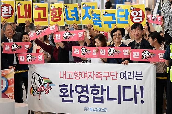 ▲ 2025-2026 아시아축구연맹(AFC) 여자 챔피언스리그(AWCL) 4강전에서 수원FC 위민을 상대하는 내고향여자축구단이 17일 인천국제공항 제1여객터미널을 통해 입국한 가운데 자주통일평화연대 등 단체 회원들이 축구단을 환영하고 있다. ⓒ연합뉴스