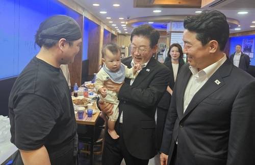 이재명 대통령 다녀간 찜닭 가게 (안동=연합뉴스) 이재명 대통령이 지난 18일 오후 경북 안동시 안동구시장 한 찜닭 가게에서 어린 아이와 기념 촬영을 하고 있다. 2026.5.19 ['행복찜닭' 제공, 재판매 및 DB 금지] sunhyung@yna.co.kr