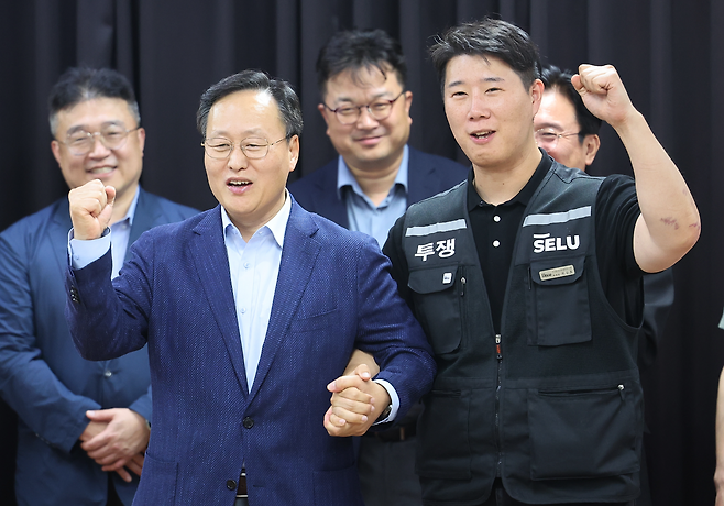 20일 경기도 수원시 장안구 경기고용노동청에서 열린 삼성전자 임금협상을 마친 후 여명구 삼성전자 DS(디바이스솔루션·반도체 사업 담당) 피플팀장과 최승호 삼성그룹 초기업노동조합 삼성전자지부 위원장이 잠정 합의한에 서명한 후 파이팅을 외치고 있다. 양회성 기자 yohan@donga.com