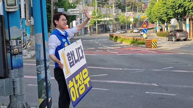 하정우 민주당 후보가 19일 아침 부산 북구 구포동 일대 교통섬에서 주민들에게 손인사를 하고 있다. 사진=이해람 기자
