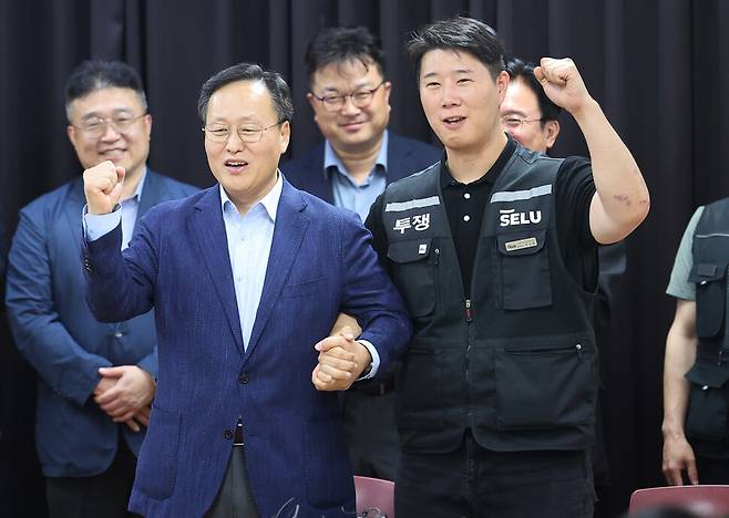 2026년 5월20일 경기도 수원시 장안구 경기고용노동청에서 열린 삼성전자 임금협상을 마친 후 여명구 삼성전자 DS(디바이스솔루션·반도체 사업 담당) 피플팀장과 최승호 삼성그룹 초기업노동조합 삼성전자지부 위원장이 잠정 합의안에 서명한 후 파이팅을 외치고 있다. 연합뉴스