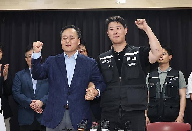 20일 경기 수원시 장안구 경기고용노동청에서 열린 삼성전자 임금협상을 마친 후 여명구 삼성전자 DS(디바이스솔루션·반도체 사업 담당) 피플팀장과 최승호 삼성그룹 초기업노동조합 삼성전자지부 위원장이 잠정 합의안에 서명한 후 파이팅을 외치고 있다. 뉴스1