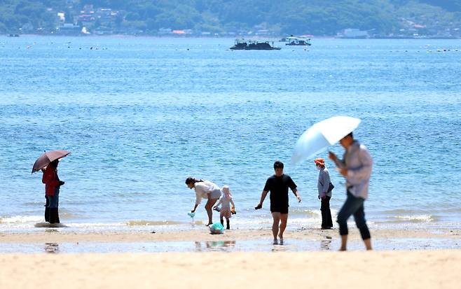 경남 창원시 마산합포구 광암해수욕장을 찾은 시민들이 산책하며 무더위를 식히고 있다. [연합]