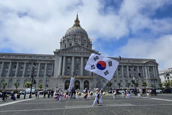 이천통신사 풍물패가 미국 샌프란시스코 시청 앞 광장에서 거리버스킹 공연을 하고 있다. 이천시 제공