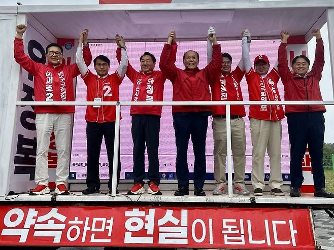 ▲ 국민의힘 유정복(왼쪽에서 세 번째) 인천시장 후보가 6·3 지방선거 공식 선거운동 첫날인 21일 오전 연수구 수인분당선 송도역 앞에서 지방선거 출마자 등과 함께 손을 번쩍 들어올리고 있다. /변성원 기자 bsw906@incheonilbo.com
