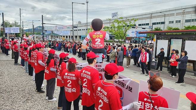 ▲ 21일 오후 양주역 광장에서 국민의힘 강수현 양주시장 후보의 출정식이 진행되고 있다. 빨간 상의를 입은 운동원들과 퇴근길 시민 등 400여 명이 광장에 집결해 후보자들의 공약 발표에 귀를 기울이고 있다. /이광덕 기자 kdlee@incheonilbo.com