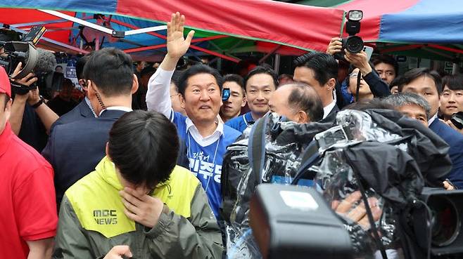 더불어민주당 정청래 총괄상임선거대책위원장이 21일 충남 공주산성시장에서 민주당 박수현 충남도지사 후보와 김영빈 충남 공주·부여·청양 국회의원 보궐선거 후보 지원 유세를 마친 뒤 시장을 돌아보다 같은 시각 지원 유세 중이던 국민의힘 장동혁 상임선대위원장을 만나 손을 흔들며 인사하고 있다.(사진=연합뉴스)