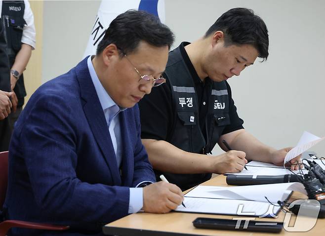 여명구 삼성전자 DS(디바이스솔루션·반도체 사업 담당) 피플팀장(왼쪽)과 최승호 삼성그룹 초기업노동조합 삼성전자지부 위원장이 20일 오후 경기 수원시 장안구 경기지방고용노동청에서 열린 삼성전자 노사교섭 결과 브리핑에서 합의안에 서명을 하고 있다. (공동취재) 2026.5.20 ⓒ 뉴스1 김영운 기자