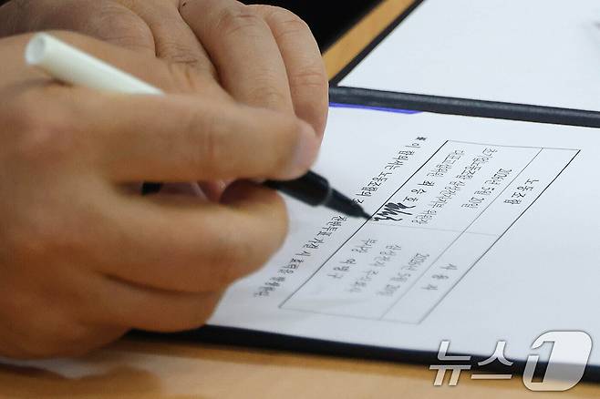 여명구 삼성전자 DS(디바이스솔루션·반도체 사업 담당) 피플팀장이 20일 오후 경기 수원시 장안구 경기지방고용노동청에서 열린 삼성전자 노사교섭 결과 브리핑에서 합의안에 서명을 하고 있다. (공동취재) 2026.5.20 ⓒ 뉴스1 김영운 기자