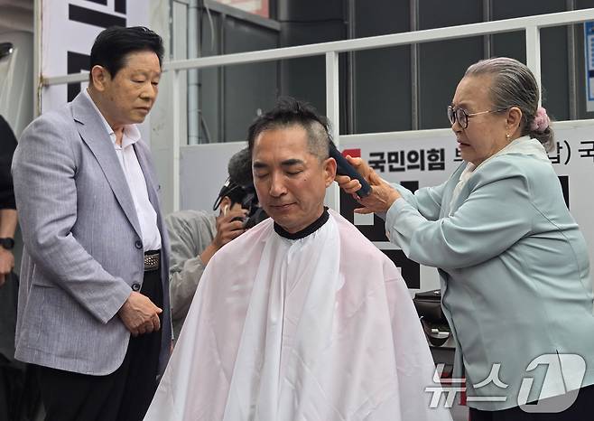 박민식 국민의힘 부산 북구갑 국회의원 후보가 6·3 지방선거 및 국회의원 재보궐선거 공식 선거운동 첫날인 21일 오후 부산 북구 구포시장 인근 쌈지공원에서 열린 출정식에서 삭발을 하고 있다. 2026.5.21 ⓒ 뉴스1 손승환