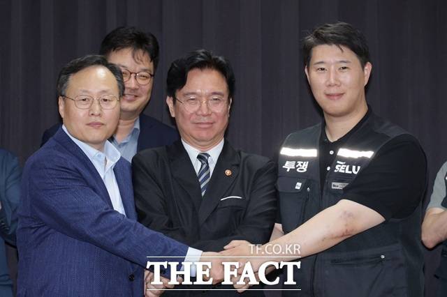 여명구(왼쪽부터) 삼성전자 DS 피플팀장과 김영훈 고용노동부 장관, 최승호 삼성그룹 초기업노동조합 삼성전자지부 위원장이 20일 경기도 수원시 장안구 경기고용노동청에서 열린 삼성전자 임금협상에서 잠정 합의안에 서명한 후 손을 맞잡고 있다. /뉴시스