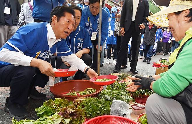 정청래 더불어민주당 총괄상임선거대책위원장이 6.3지방선거 공식 선거운동 첫날인 21일 충남 공주시 산성시장을 찾아 한 상인과 인사 한 뒤 콩을 구입하고 있다. 김성태 객원기자
