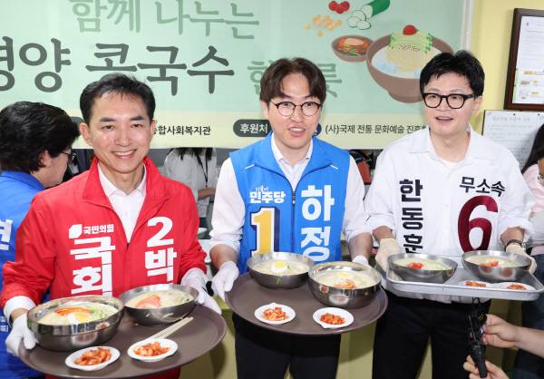 국민의힘 박민식(왼쪽), 더불어민주당 하정우, 무소속 한동훈 부산 북구갑 국회의원 보궐선거 후보가 21일 부산 북구 남산정종합사회복지관에서 열린 콩국수 나눔 행사에 참석해 콩국수 배식 봉사를 하고 있다. 연합뉴스