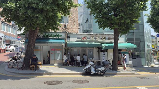 Diners have bowls of noodles at Hongtak Mokpojib. [WOO JI-WON]