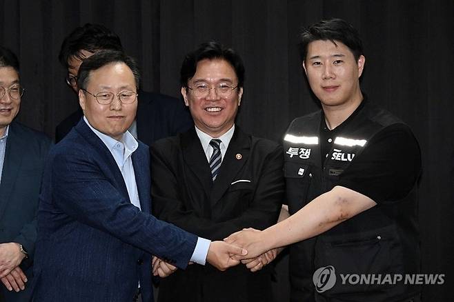 20일 경기도 수원시 장안구 경기고용노동청에서 열린 삼성전자 임금협상을 마친 후 여명구 삼성전자 DS(디바이스솔루션·반도체 사업 담당) 피플팀장과 최승호 삼성그룹 초기업노동조합 삼성전자지부 위원장이 잠정 합의안에 서명한 후 김영훈 고용노동부 장관과 기념촬영을 하고 있다. [사진출처=연합뉴스]