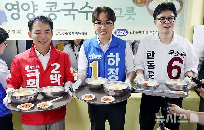 [부산=뉴시스] 김진아 기자 = 제9회 전국동시지방선거 및 국회의원 재·보궐선거의 공식 선거운동이 시작된 21일 부산 북구갑 국회의원 보궐선거 국민의힘 박민식(왼쪽부터), 더불어민주당 하정우, 무소속 한동훈 후보가 부산 북구 남산정복지관에서 열린 콩국수 나눔행사에서 콩국수를 나르고 있다. 2026.05.21. bluesoda@newsis.com