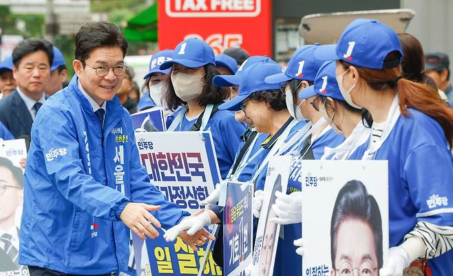 더불어민주당 정원오 서울시장 후보가 21일 서울 광진구 자양사거리에서 열린 거리 유세에서 선거운동원들과 인사를 나누고 있다.