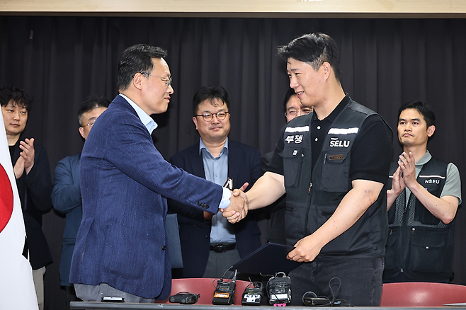 삼성전자 노사 협상이 잠정 합의된 20일 경기도 수원시 장안구 경기지방고용노동청에서 최승호(오른쪽) 삼성전자 노조 공동투쟁본부 위원장과 여명구 DS(디바이스솔루션·반도체 사업 담당) 피플팀장이 손을 맞잡고 있다. 이날 삼성전자 노사는 김영훈 고용노동부 장관의 중재로 다시 임금협상에 나섰다. 연합뉴스