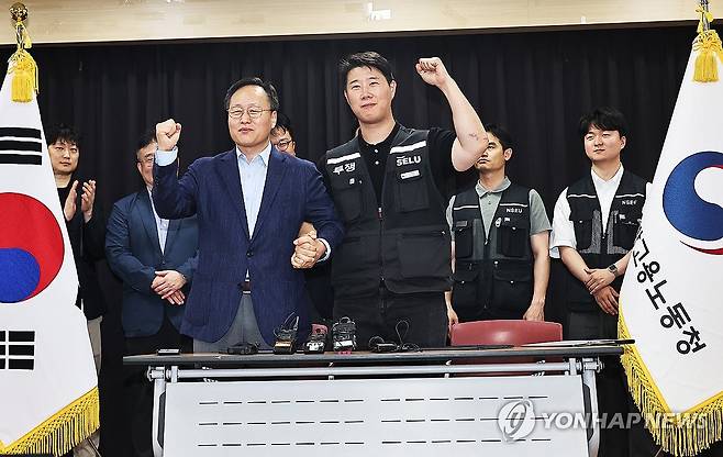 삼성전자 파업 유보 (수원=연합뉴스) 홍기원 기자 = 20일 경기도 수원시 장안구 경기고용노동청에서 열린 삼성전자 임금협상을 마친 후 여명구 삼성전자 DS(디바이스솔루션·반도체 사업 담당) 피플팀장과 최승호 삼성그룹 초기업노동조합 삼성전자지부 위원장이 잠정 합의안에 서명한 후 파이팅을 외치고 있다. 2026.5.20 [공동취재] xanadu@yna.co.kr