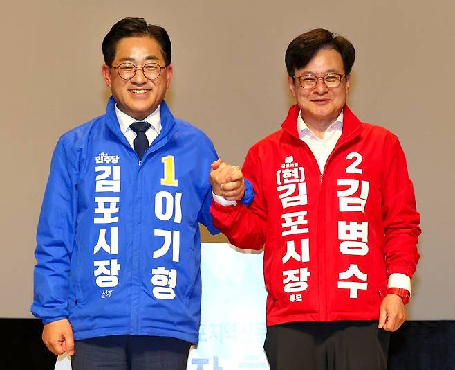 ▲ 22일 열린 김포시장 후보자 토론회에서 더불어민주당 이기형 후보와 국민의힘 김병수 후보가 손을 맞잡은 채 기념촬영을 하고 있다. 이날 토론에서는 서울지하철 5호선 연장과 중앙정부 협력, 민선 8기 시정 성과를 둘러싼 정책 경쟁이 이어졌다. /박성욱 기자 psu1968@incheonilbo.com