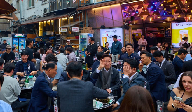 이재명 대통령이 21일 서울 익선동 골목 야장에서 시민들 사이에 앉아 식사를 하고 있다. 퇴근 시간 골목에 인파가 몰리면서 일대는 순식간에 발길이 뒤엉켰다. (청와대)