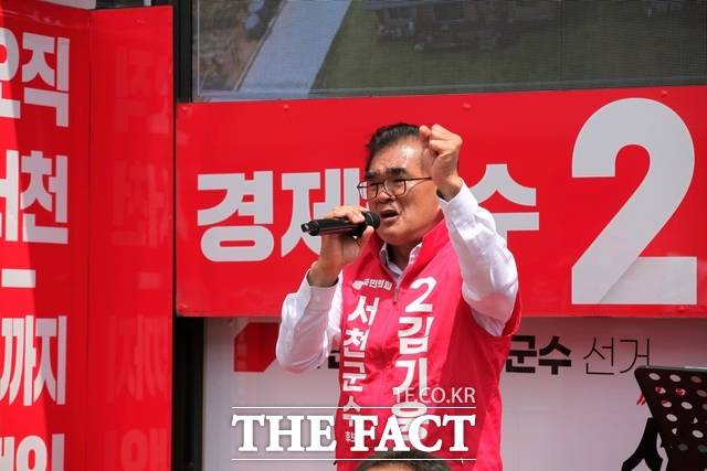 김기웅 국민의힘 충남 서천군수 후보가 장항전통시장 유세 차량에서 지지자들에게 연설하며 손을 들어 호소하고 있다. /노경완 기자