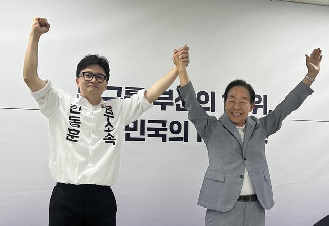 김영삼(YS) 전 대통령 차남인 김현철 김영삼 대통령기념재단 이사장(오른쪽)이 23일 오후 부산 북갑 국회의원 보궐선거에 출마한 무소속 한동훈 후보(왼쪽) 선거캠프에서 지지를 선언하는 기자회견을 한 뒤 만세하고 있다.  연합뉴스