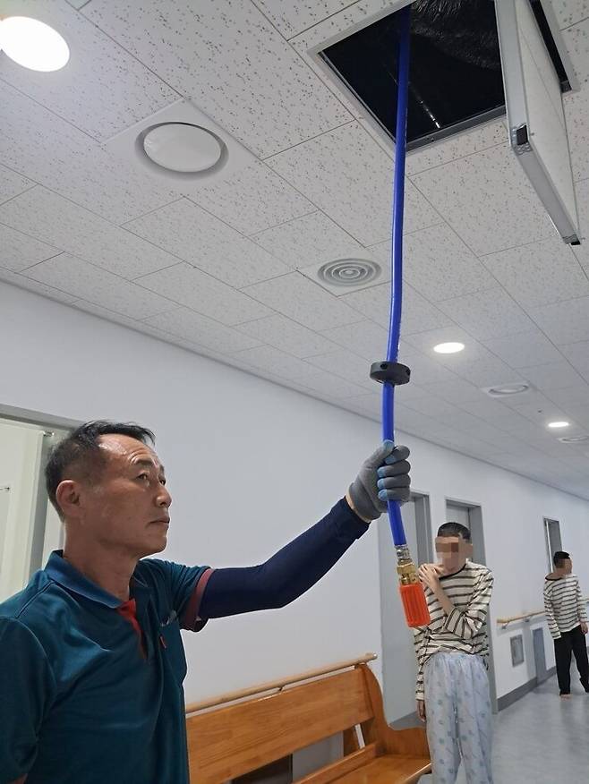 신세계병원 집중병동의 한 보호사가 오물 등으로 내부 환경이 훼손됐을 때 바로 물세척을 할 수 있는 천장 매립형 고압세척기를 빼내어 시범을 보이고 있다.