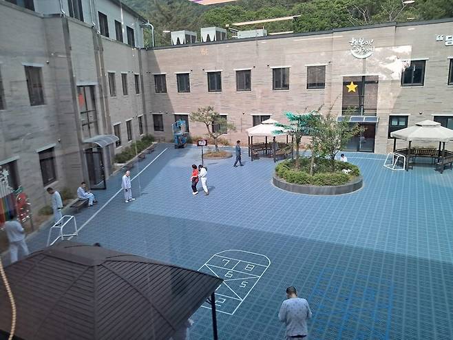 신세계효병원 산하 나누리발달센터 창문으로 본 중앙정원. 환자들이 거닐고 있다.