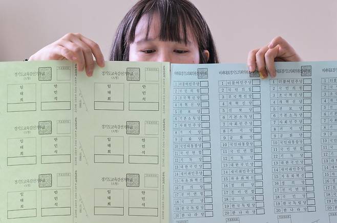 경기도선거관리위원회 관계자가 18일 경기 수원시의 한 출력 인쇄업체에서 제9회 전국동시지방선거 경기도의회 의원선거와 경기도교육감 투표용지(왼쪽)를 들어 보이고 있다. 교육감 선거엔 다른 투표용지와 달리 번호가 기재되지 않는다. 뉴시스