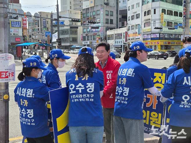 국민의힘 이상일 용인시장 후보가 22일 오전 선거 유세를 마친 뒤 더불어민주당 선거운동원들과 인사를 나누고 있다. 정성욱 기자