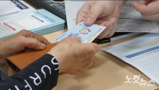 지난 8일 전주시 서신동 주민센터에서 고유가지원금을 신청한 주민이 선불카드를 받고 있다. 기사와 직접적인 관계 없음. 심동훈 기자