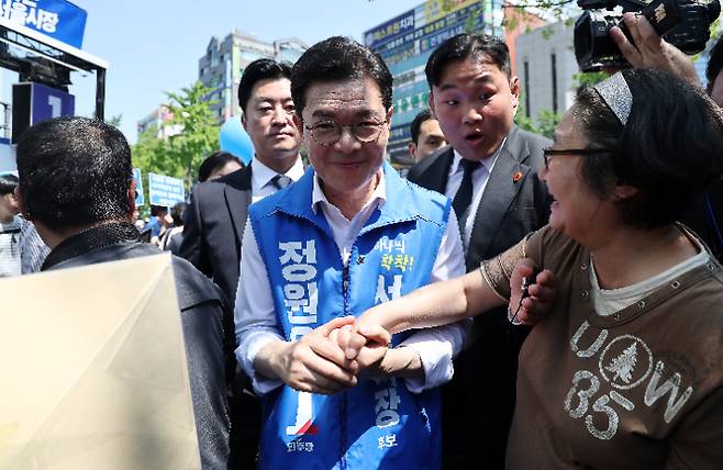 더불어민주당 정원오 서울시장 후보가 22일 서울 롯데백화점 노원점 앞에서 선거 유세를 마친 후 이동하며 시민과 악수를 하고 있다. 연합뉴스